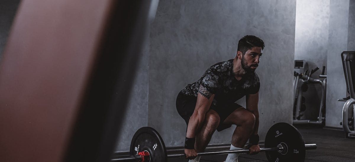 Man lifting weights in gym, displaying strength and focus. Ideal for fitness and training themes.